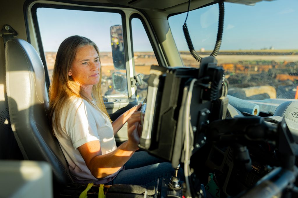 Female Friona employee working on computer inside feedyard truck