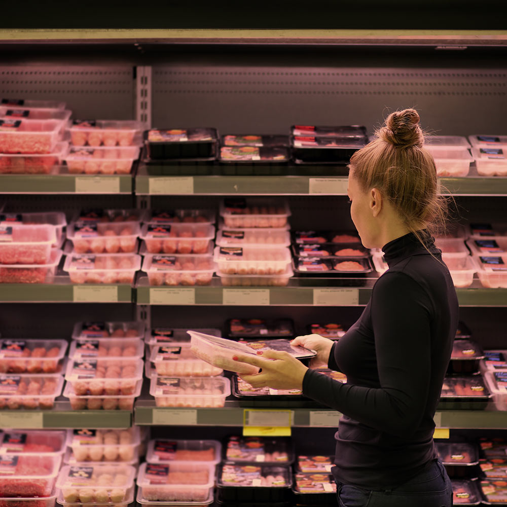 Woman shopping for beef at a grocery store