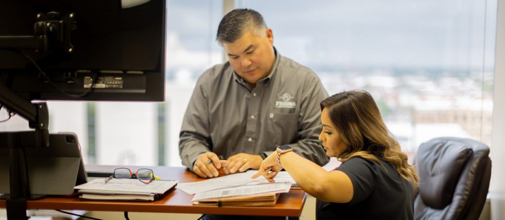 Male and female Friona employees inside office