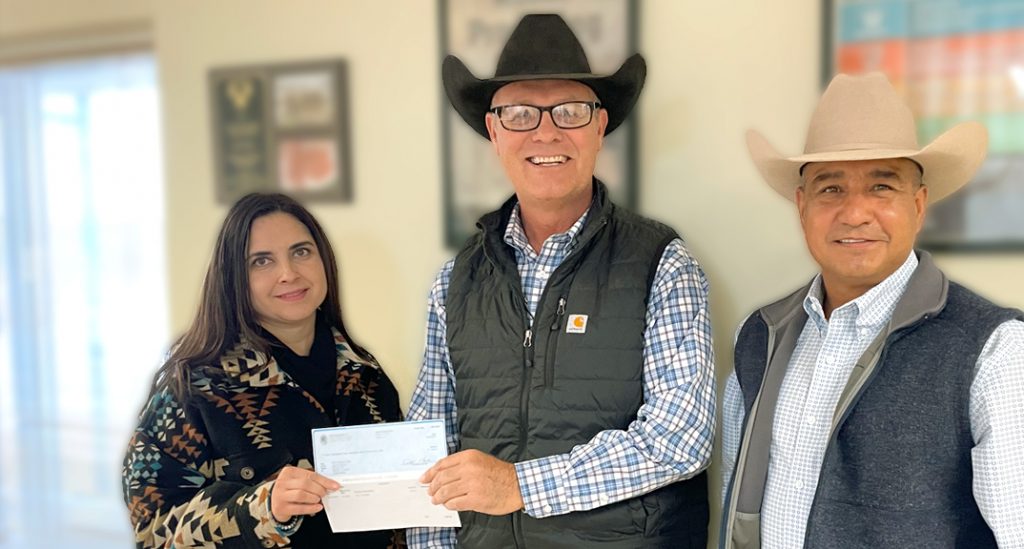 Two male Friona employees presenting a check to a local organization